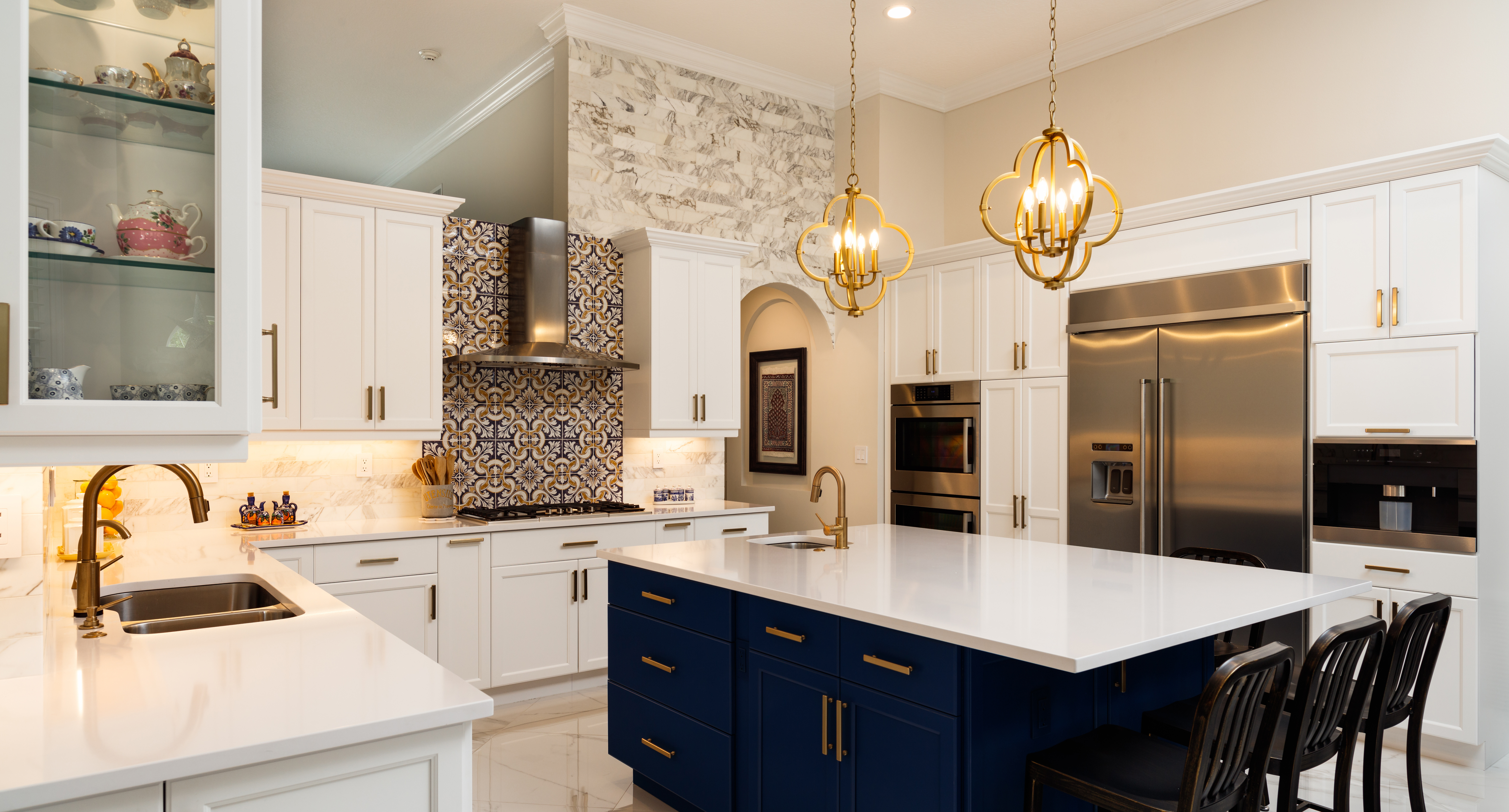 Renovated kitchen with gold chandeliers and blue island